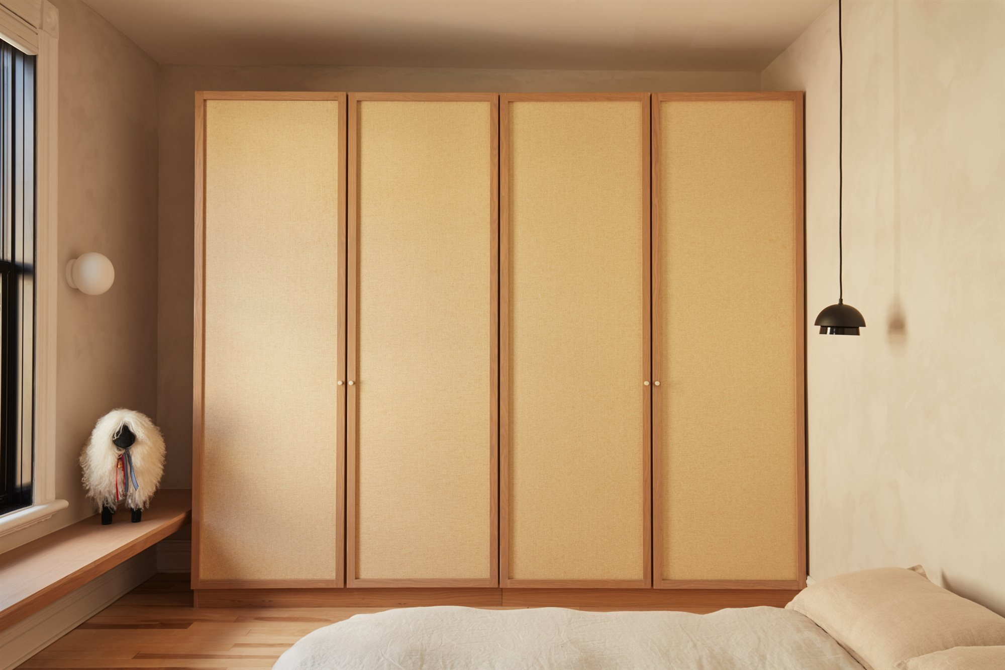 Dormitorio con armario de madera empotrado y paredes de color ocre de un piso en Montreal