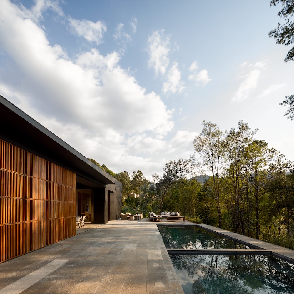 Casa en mitad del bosque con piscinas y fachada de madera