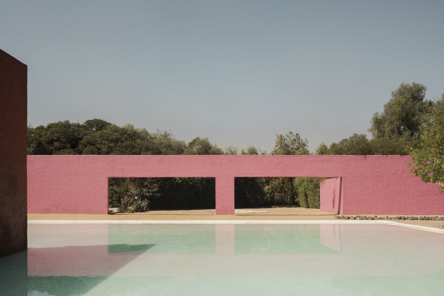 Patio con edificio de color rosa del arquitecto mexicano Luis Barragan