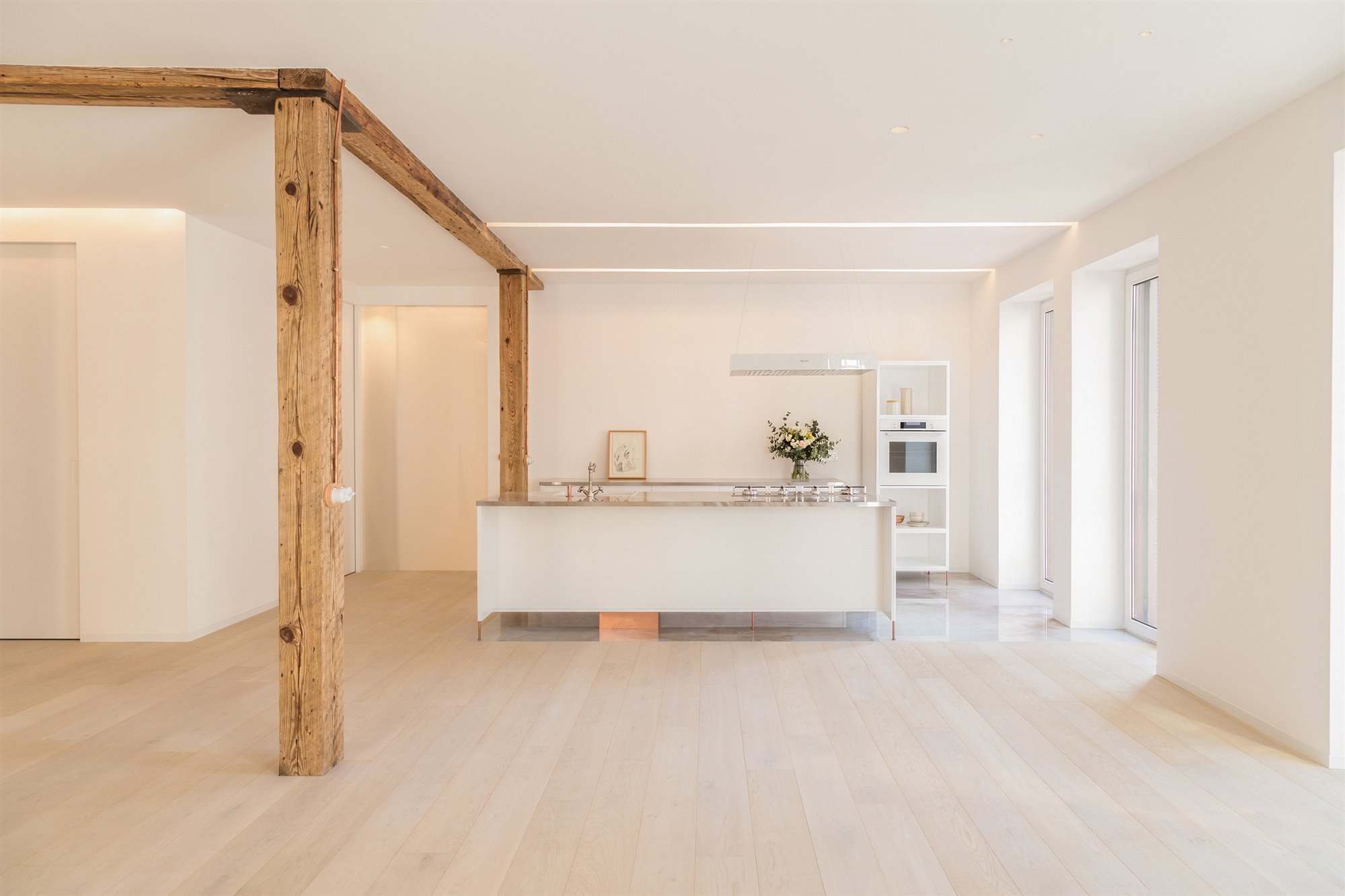 piso con cocina blanca y columna de madera original