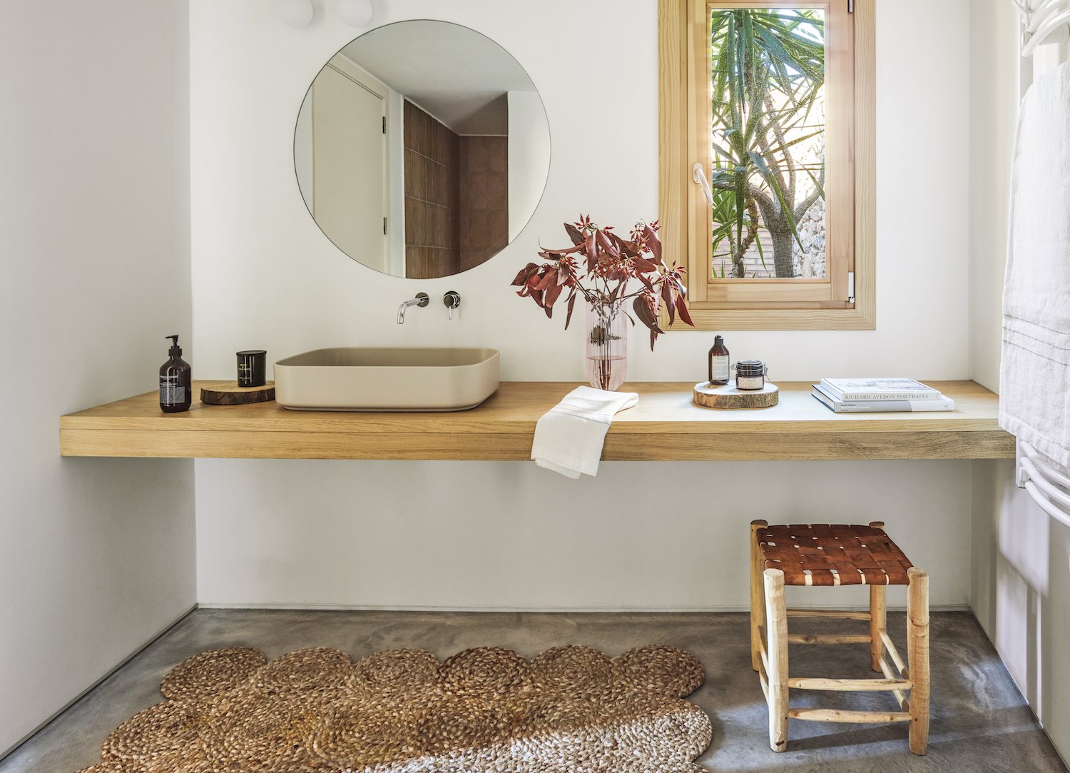 ban~o moderno con espejo circular y mueble de lavabo rectangular