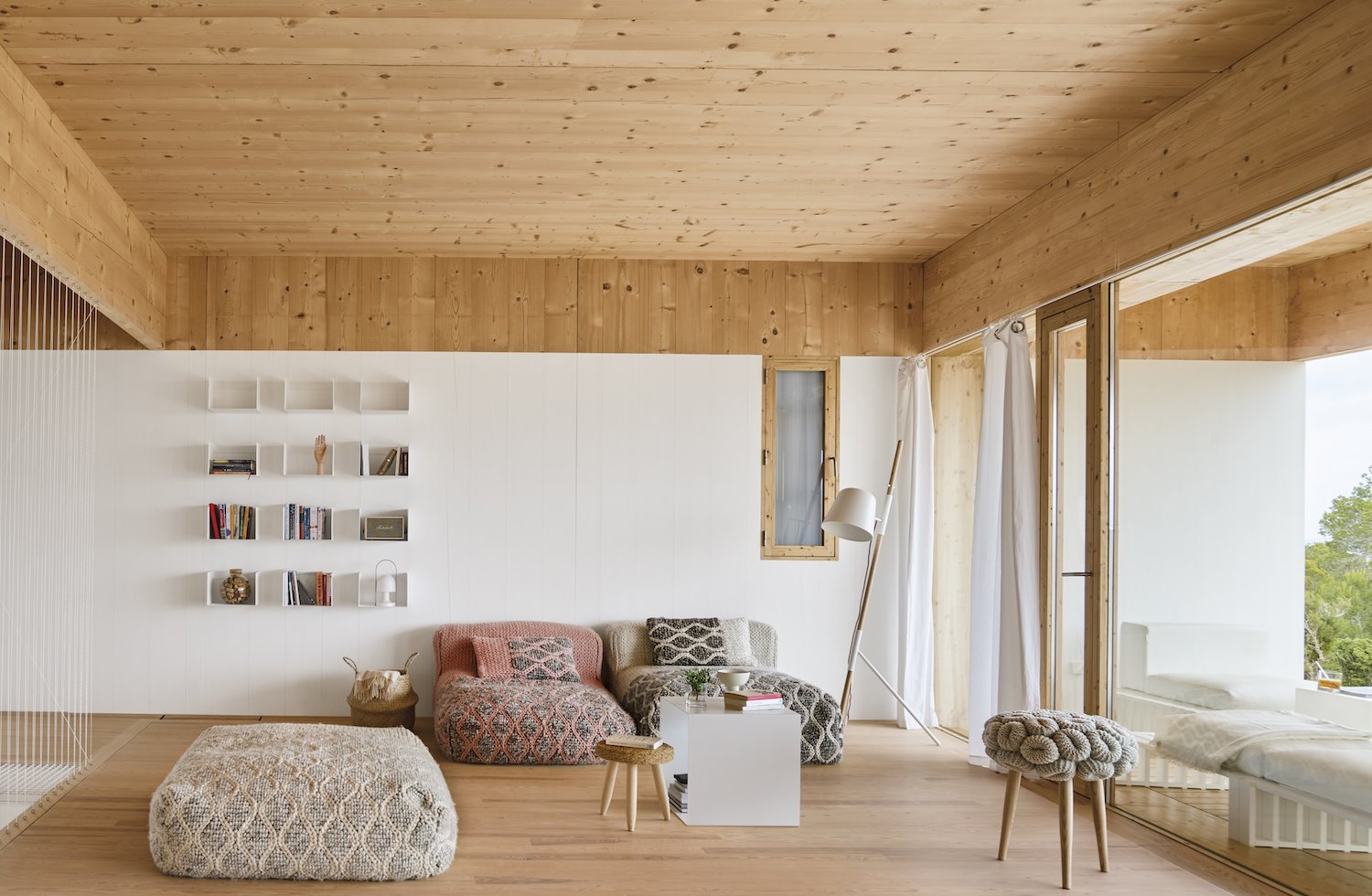 Salon con suelo y techo de pared con sofas tipo puf. Iluminación