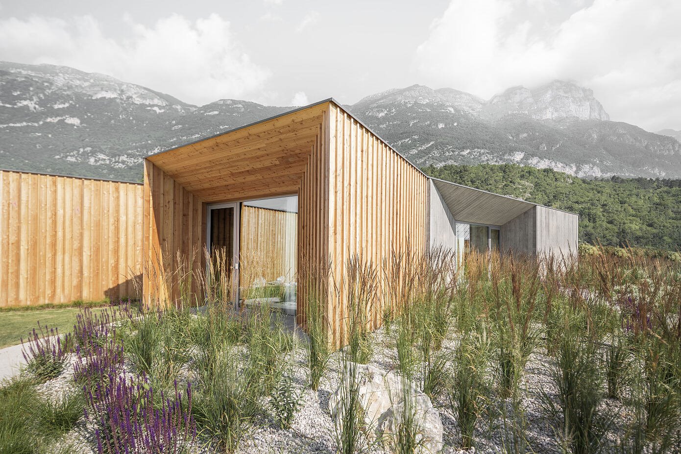 Casa de campo con fachada de madera rodeada de naturaleza entrada