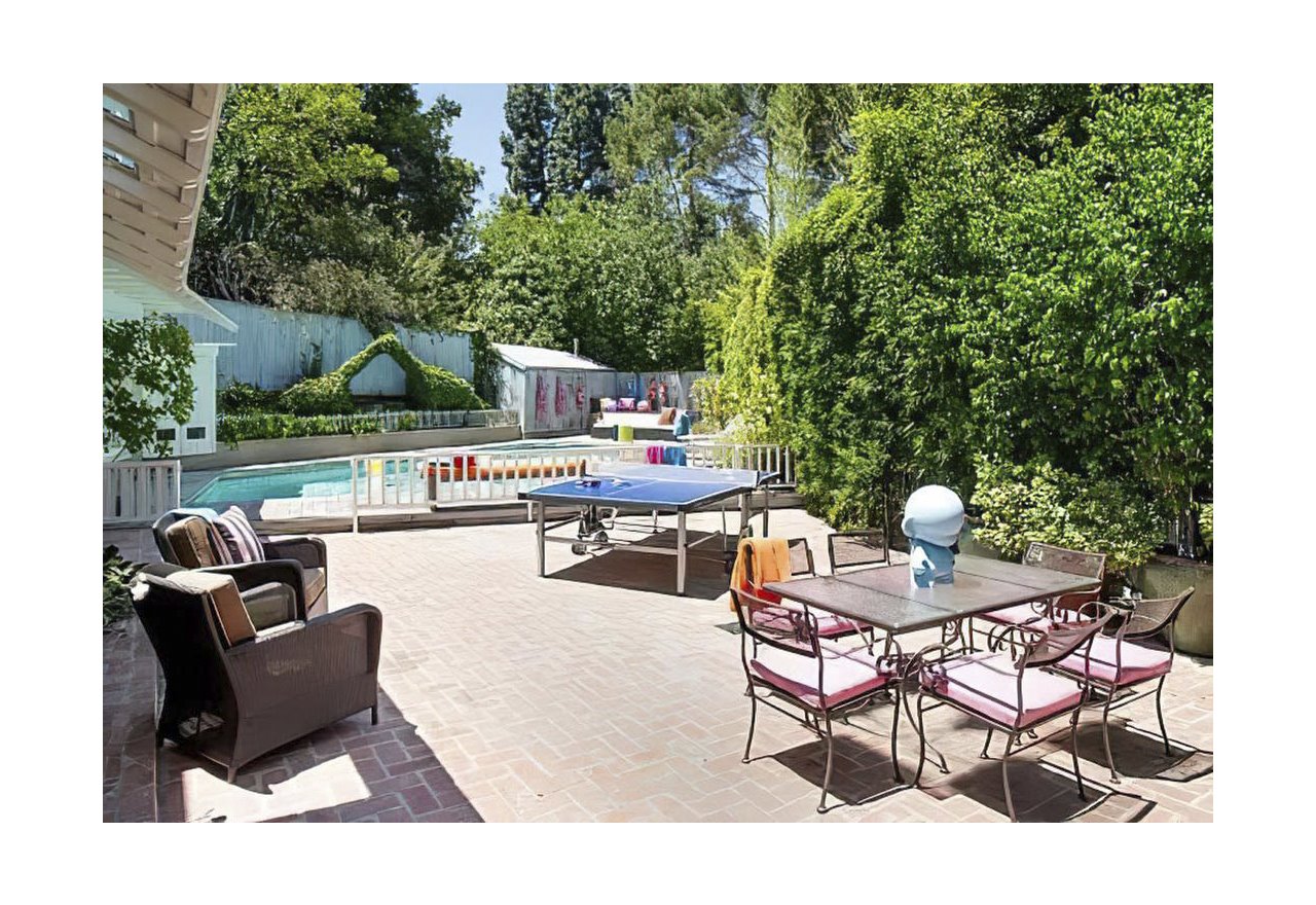 Casa en Los Angeles de Harry Styles y Olivia Wilde jardin exterior con piscina y mesa de ping pong