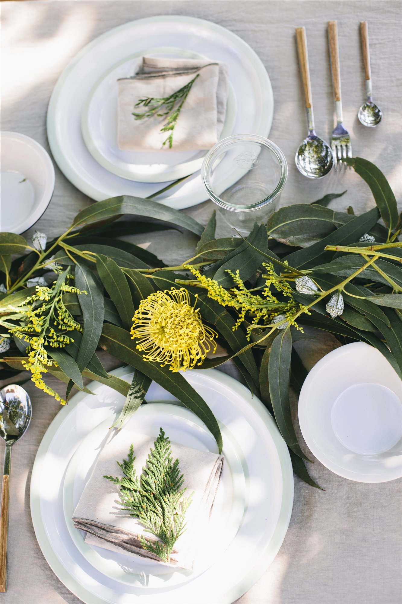 Platos blancos en una mesa de comedor con flores amarillas. Cómo recoger
