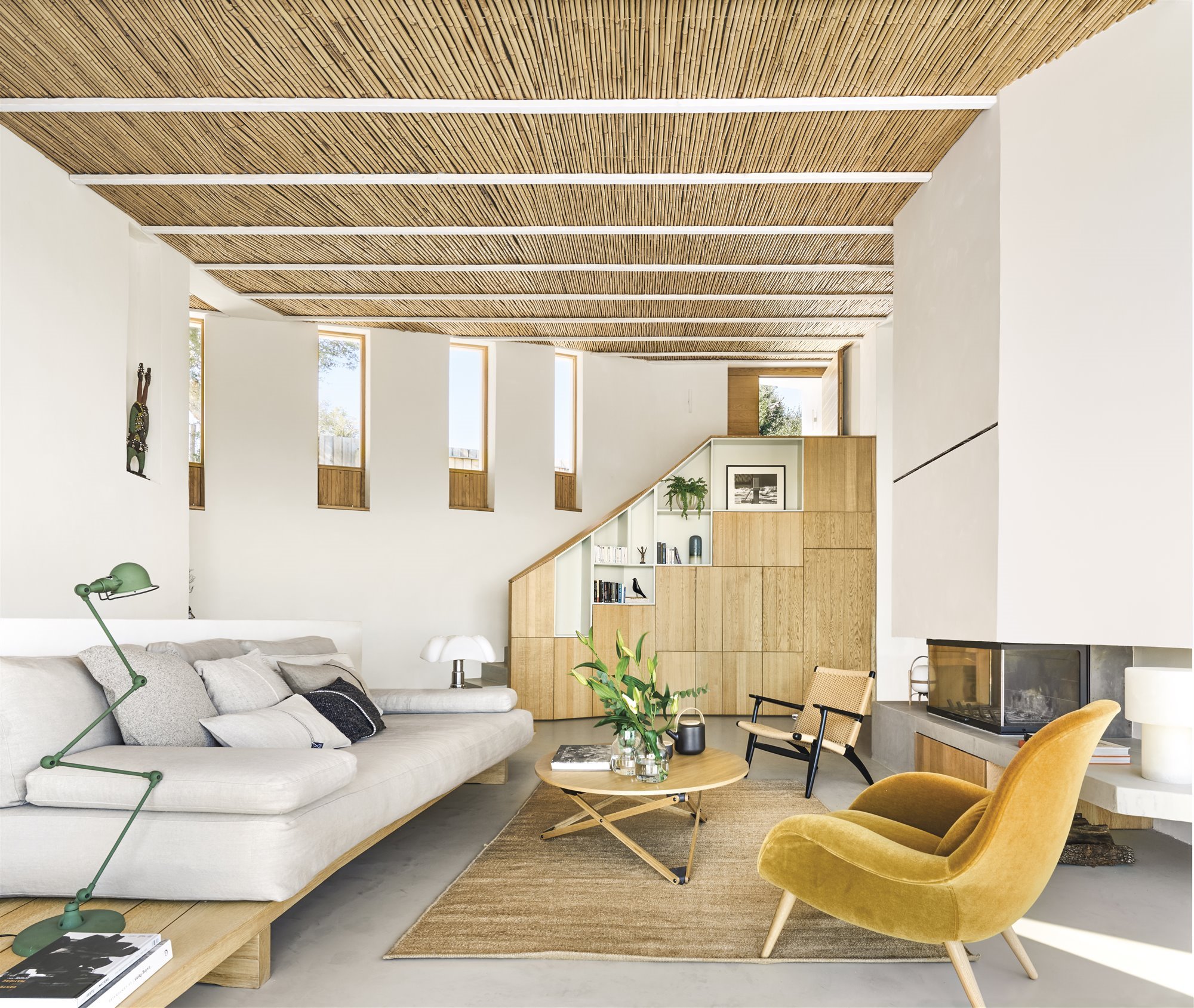 Salon de una casa moderna con techos de fibras naturales y sofá blanco