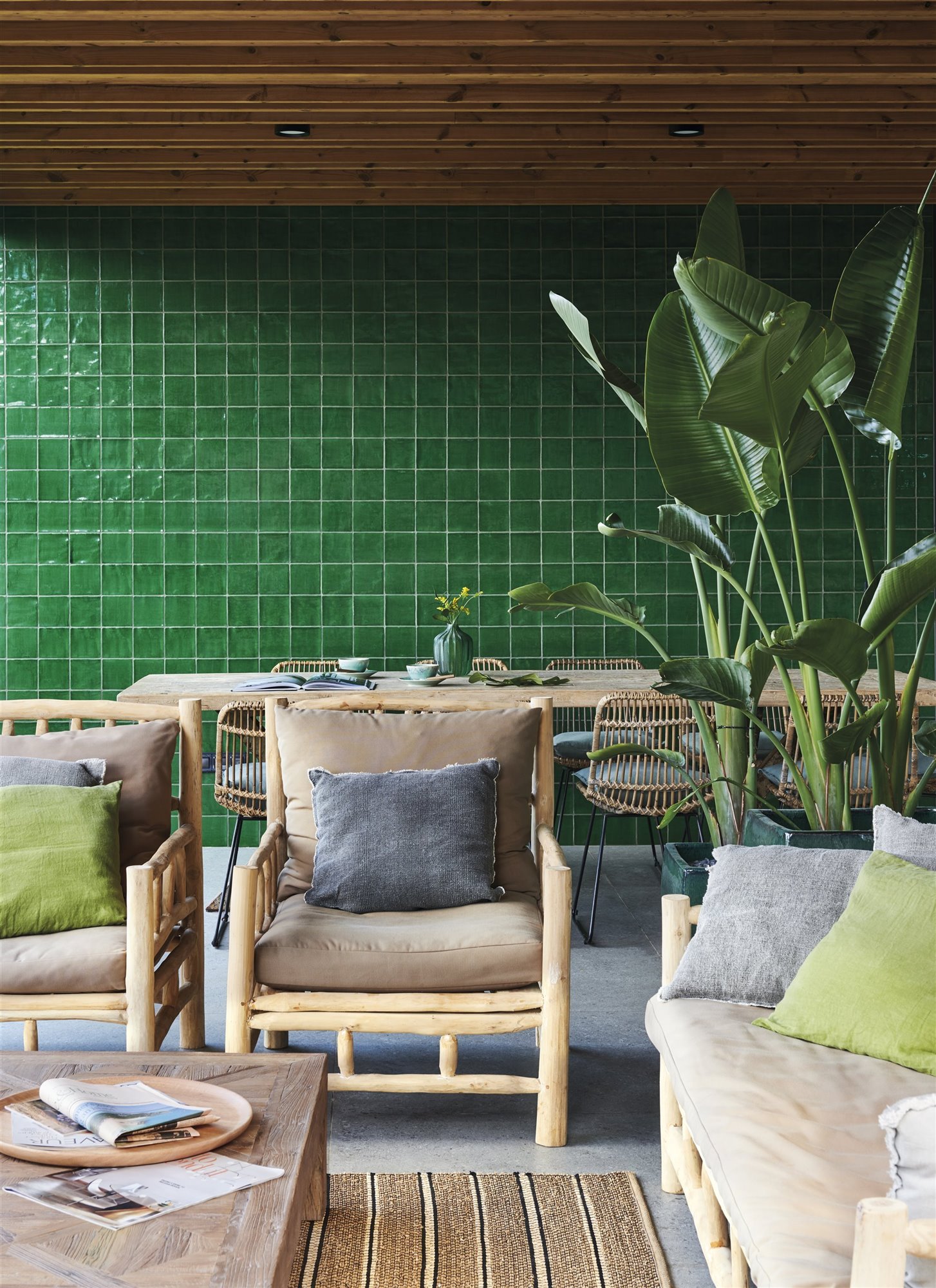Salón con azulejos verdes y plantas.