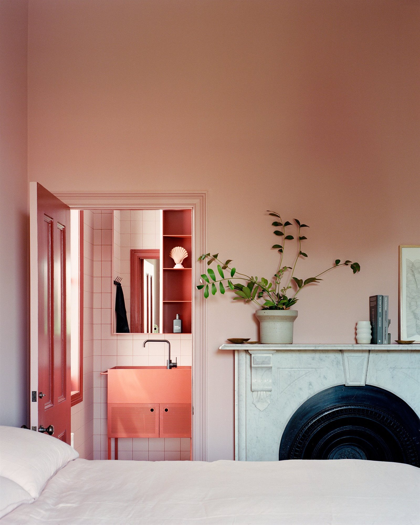 Dormitorio con chimenea en color rojo y rosa. Temperatura de color