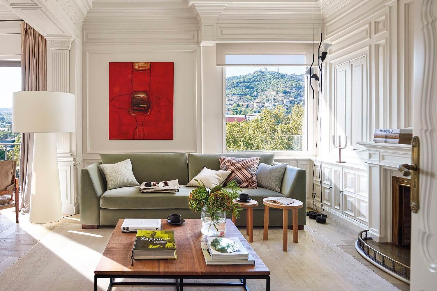 salón. con sofá verde, lámapara XL blanca y cuadro rojo