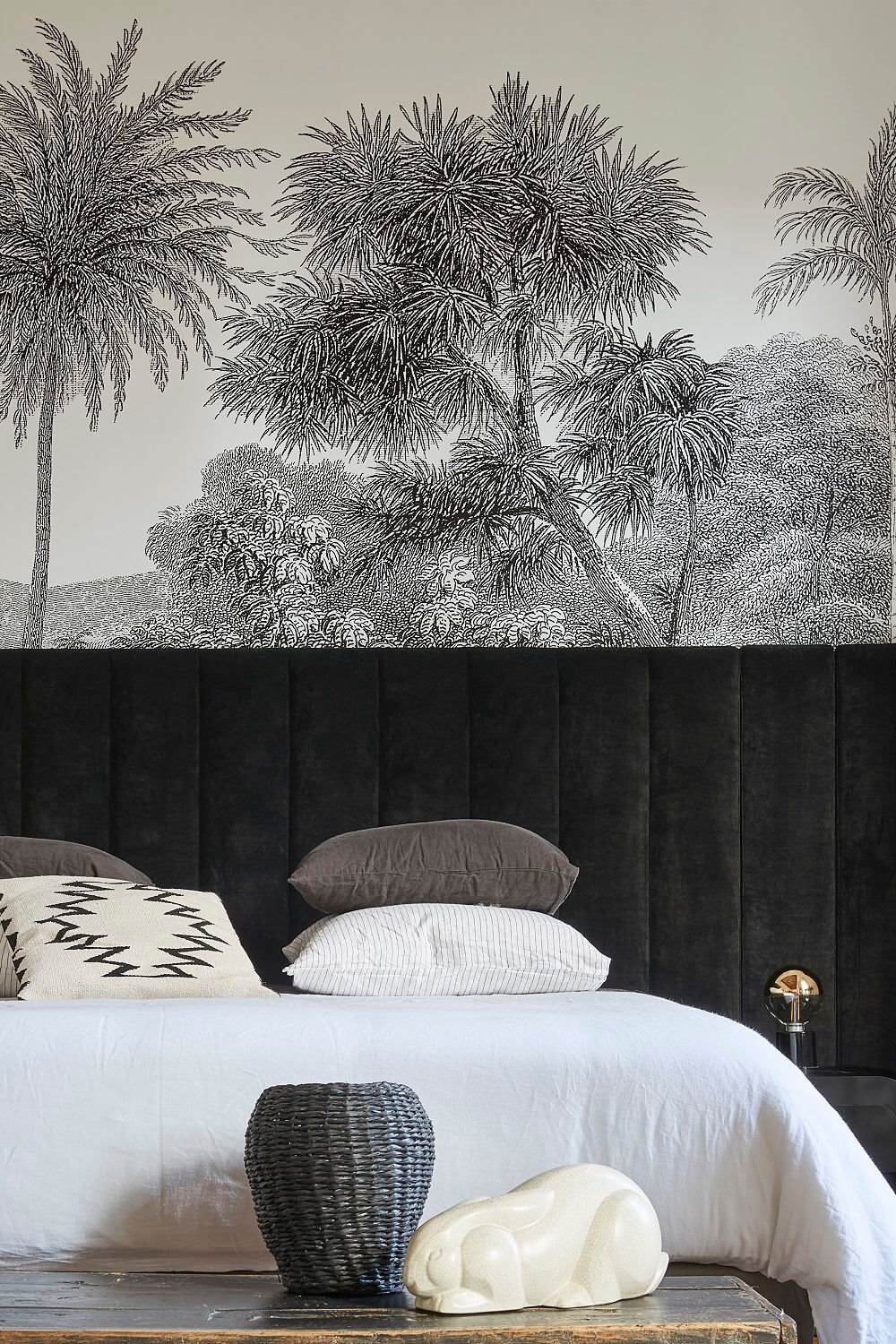Dormitorio con cabecero tapizado y papel pintado.