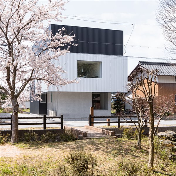Una moderna casa de hormigón y metal con vistas a los cerezos