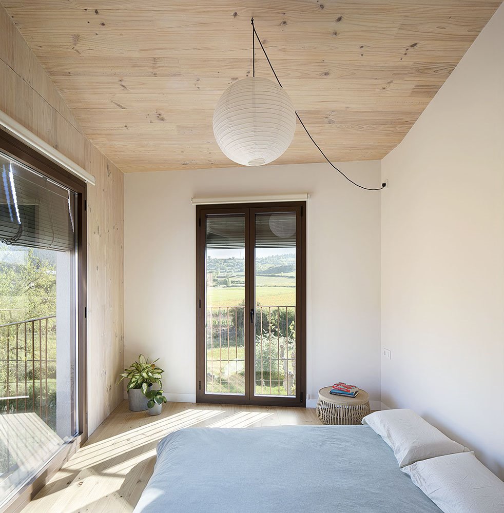 Dormitorio con pared, suelo y techo de madera.