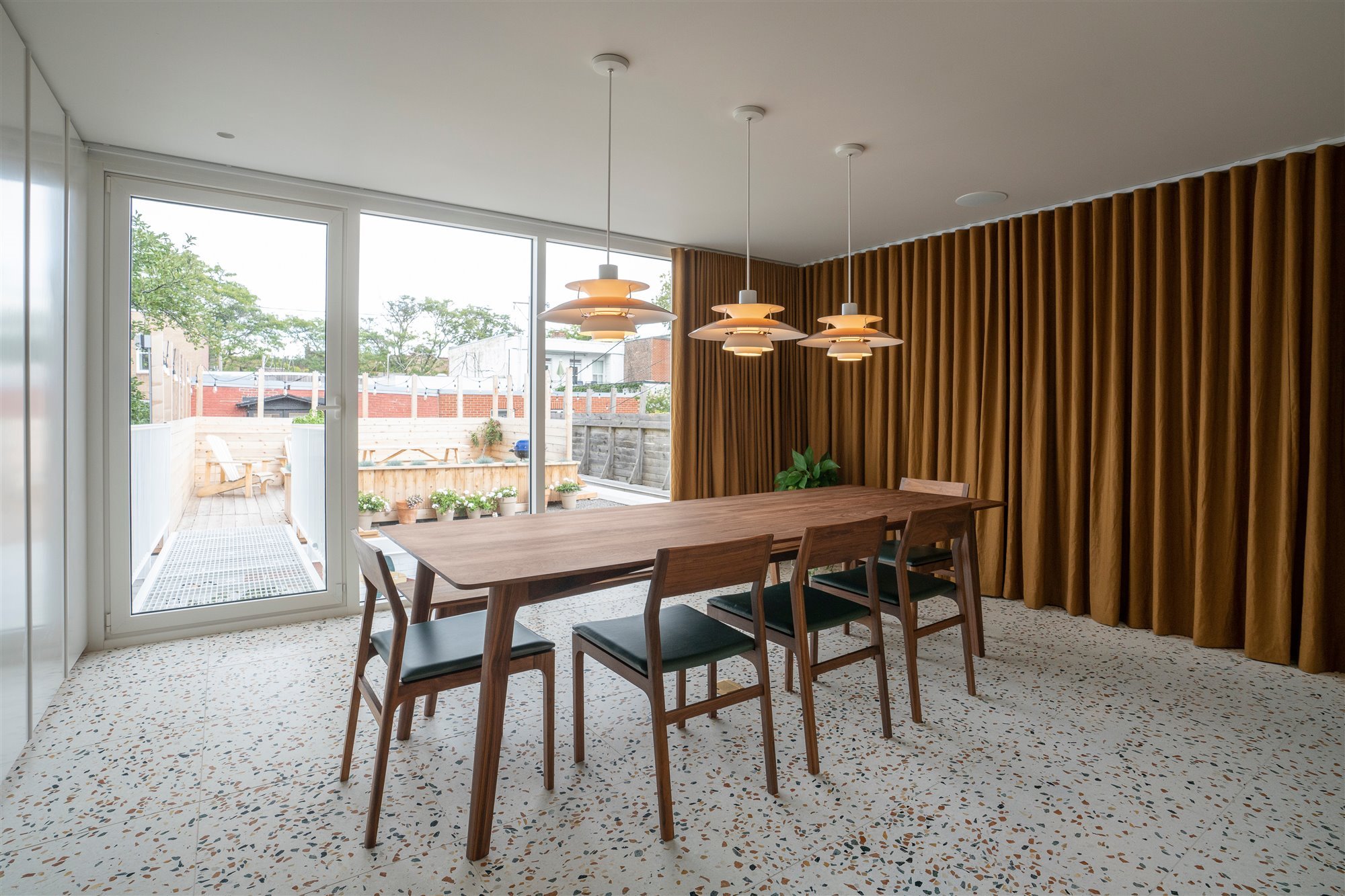 Comedor con mesa de madera y suelos de terrazo. 