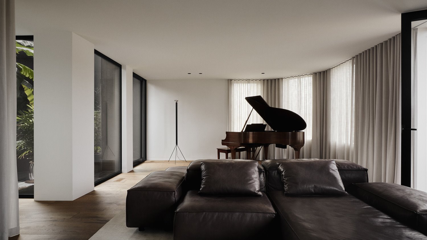 Salo´n con sofá negro y piano.