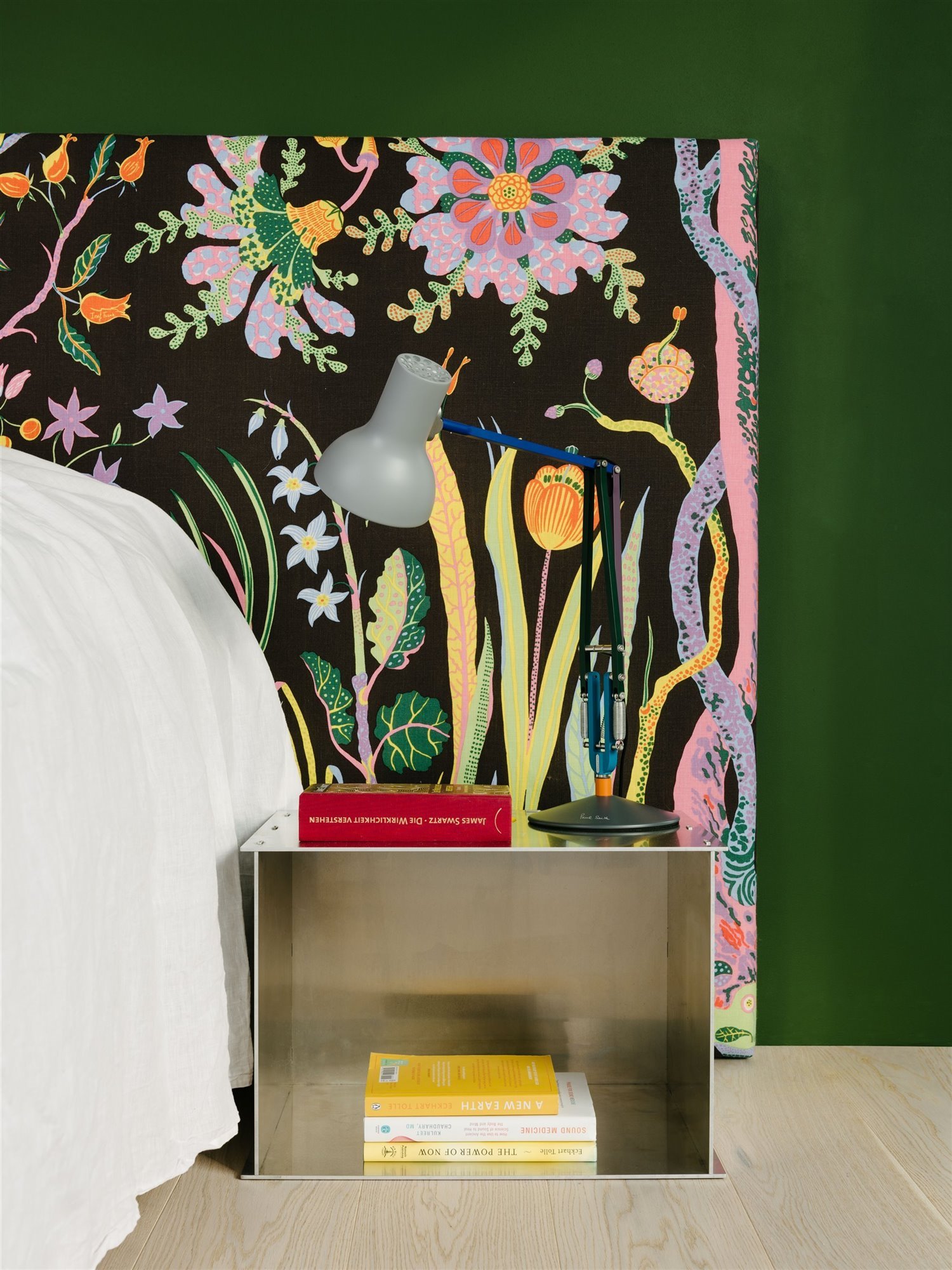 dormitorio con cabecero estampado con colores y mesilla de noche