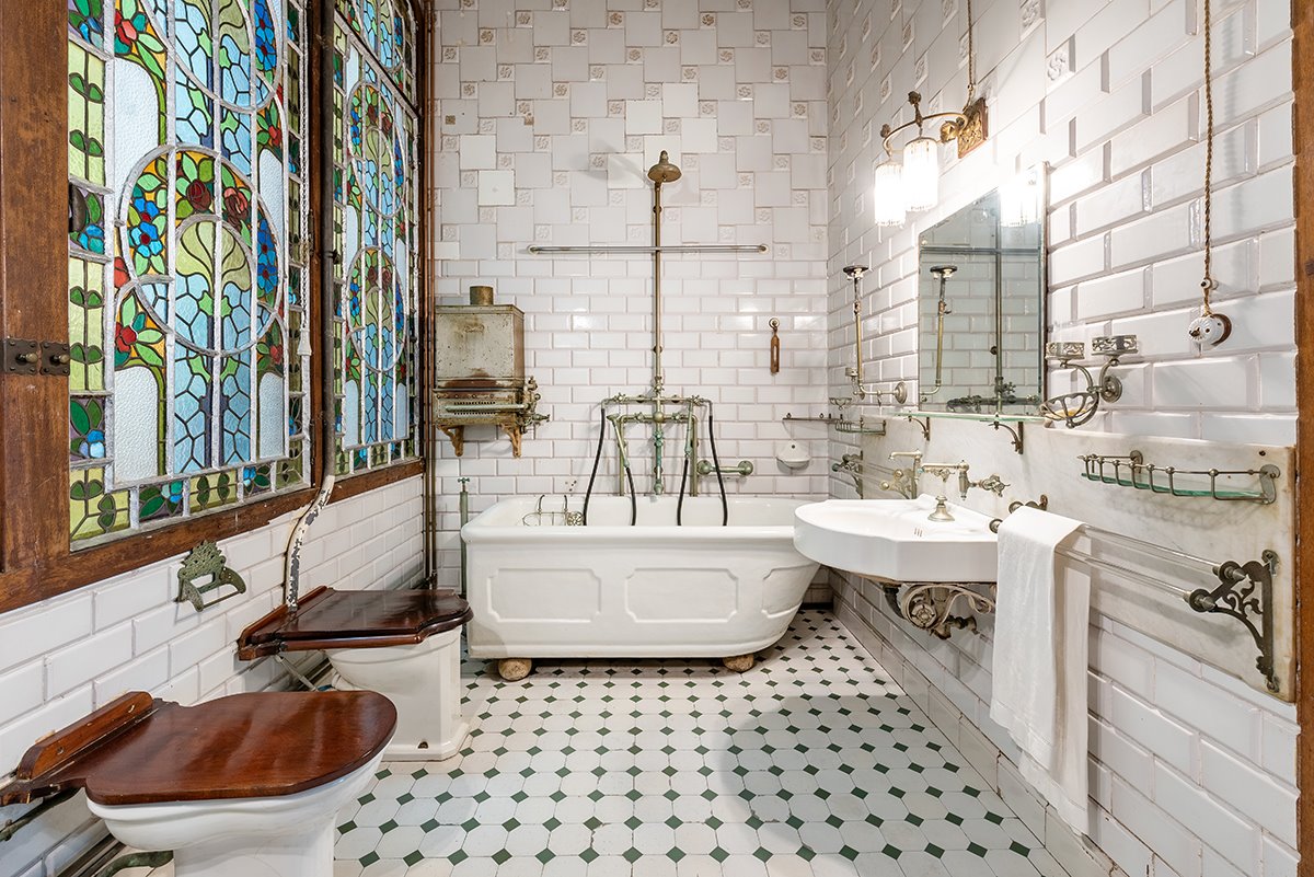 En el baño, destacan las vidrieras de colores y los azulejos de las paredes y el suelo, así como las dimensiones del lavamanos y los inodoros. 