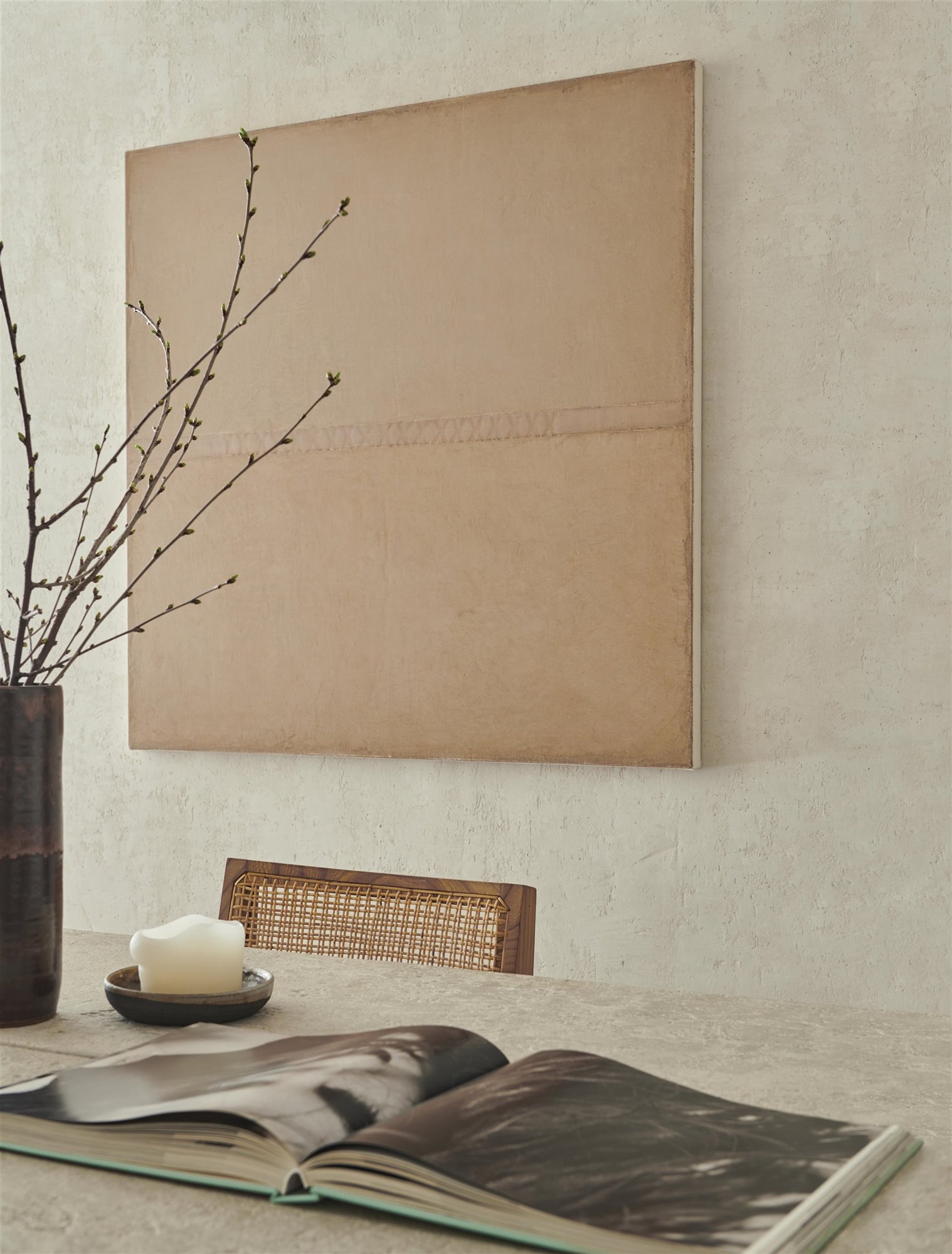 mesa comedor de cemento con silla de madera y mimbre, cuadro, vela y jarrón minimalista estilo japonés