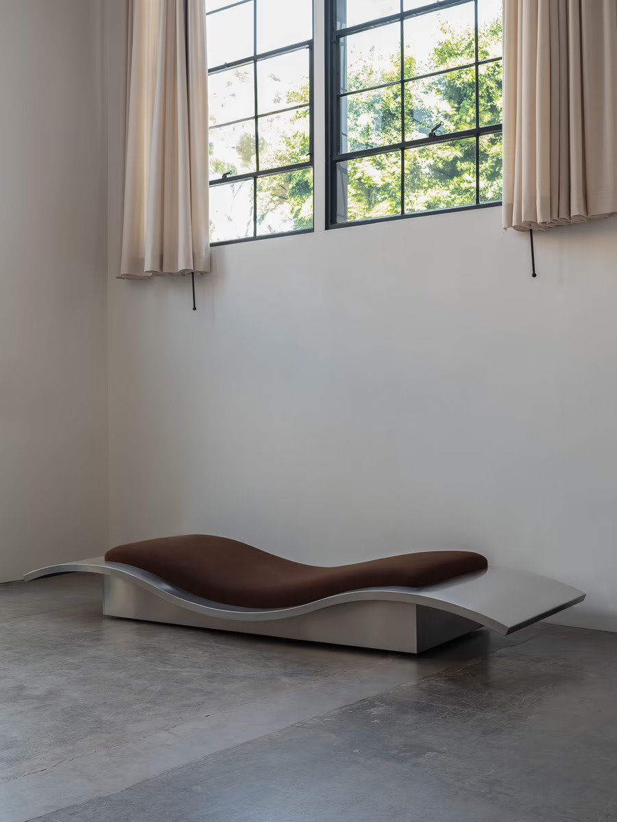 En una de las salas principales, la chaise longue Flying Carpet de Maria Pergay, creada en 1968, conversa con los ventanales originales de la casa instalados a una doble altura para preservar la privacidad.