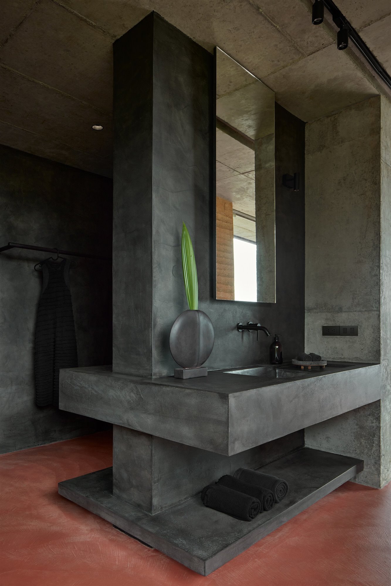 Baño con mueble de obra de cemento negro. 