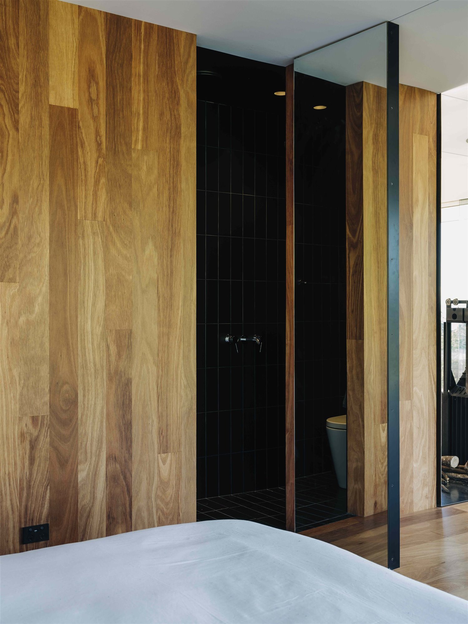 Baño negro con puertas de madera.