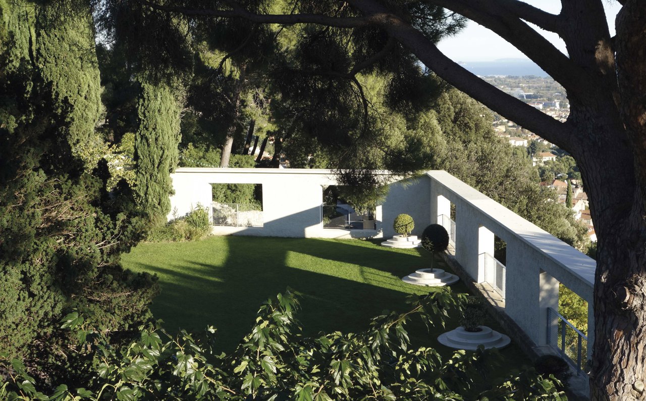 La terraza que da acceso a la casa, acotada por un muro con arcos y vistas a Hyerès