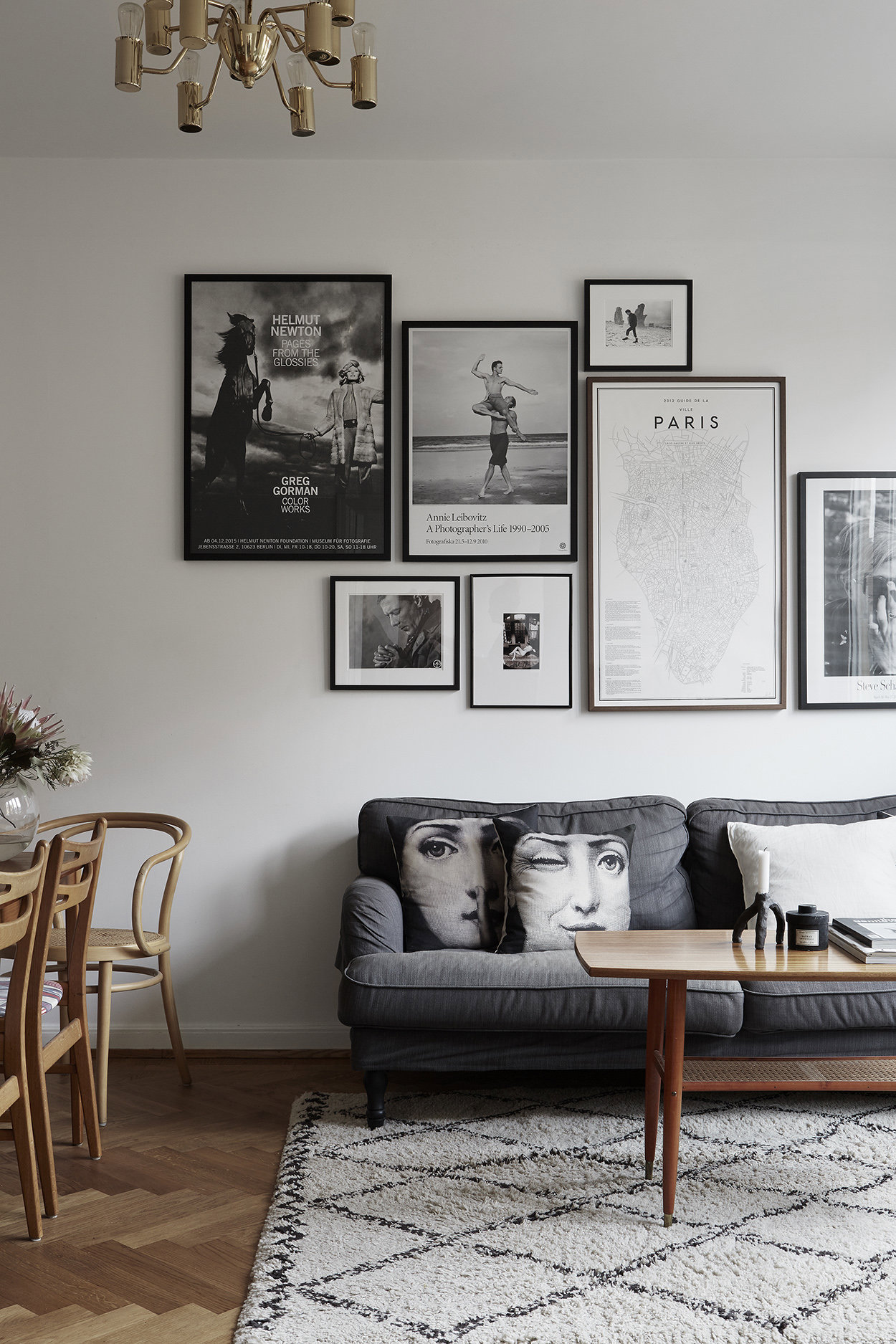 Salon de un piso con cuadros en la pared y sofa gris
