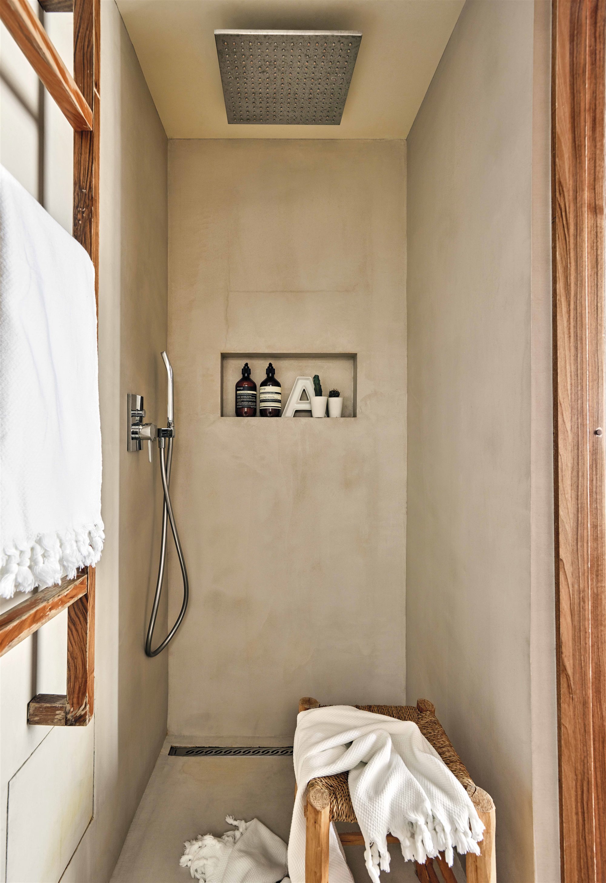 ducha minimalista con estante de obra y colgador de madera