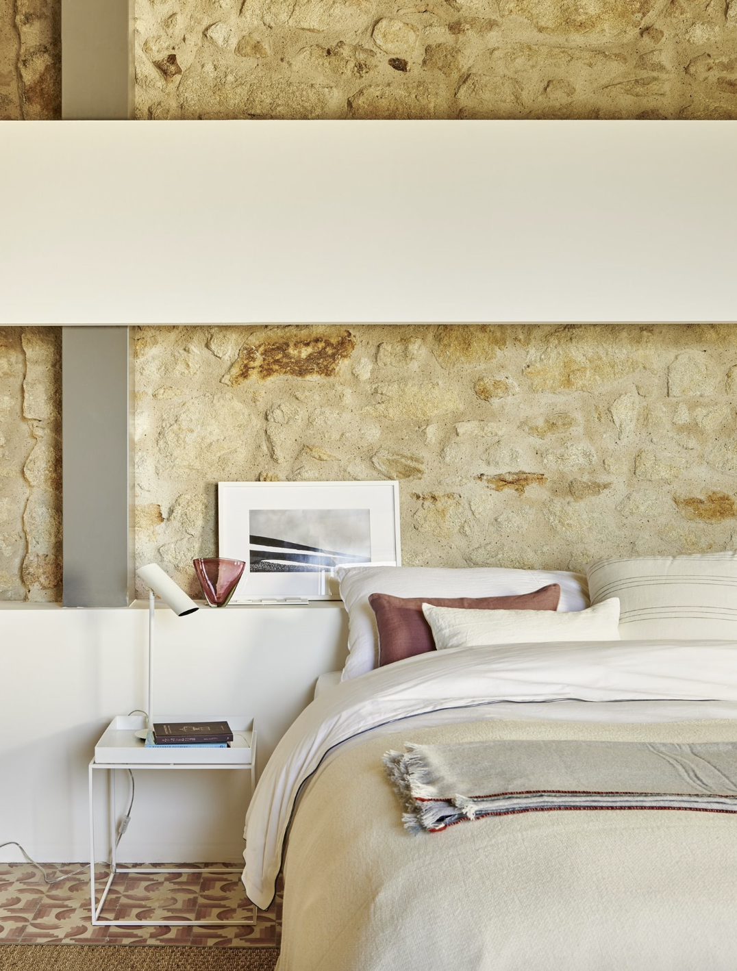 Dormitorio con pared de piedra y estilo natural. 