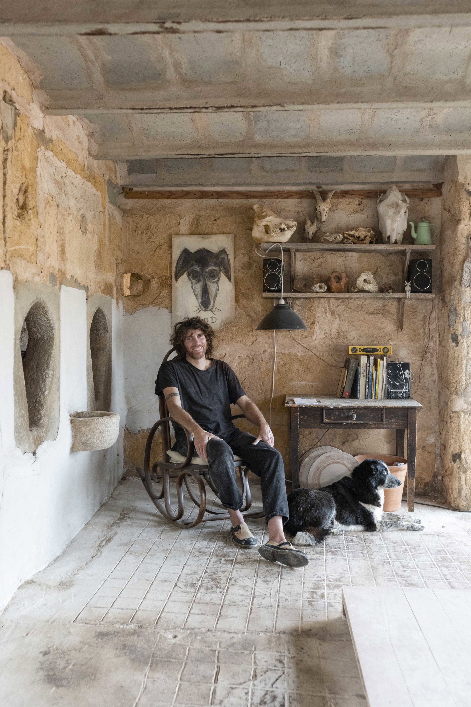 Jaume con su perra Tota (detrás, dibujada por Roig) en su taller y cráneos de vacas, ovejas, cerdos y zorros