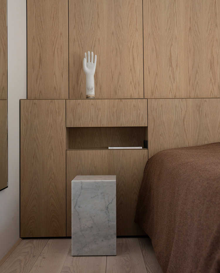 Dormitorio con hornacina en el cabecero de madera, estructura de mármol a modo de mesilla de noche.