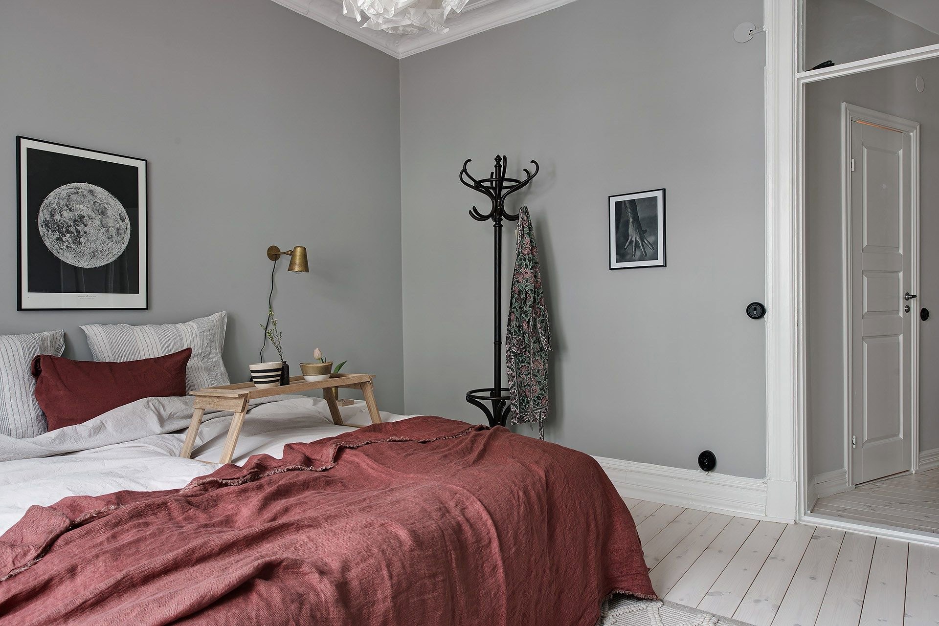 Dormitorio con ropa de cama en color rojo y paredes grises.