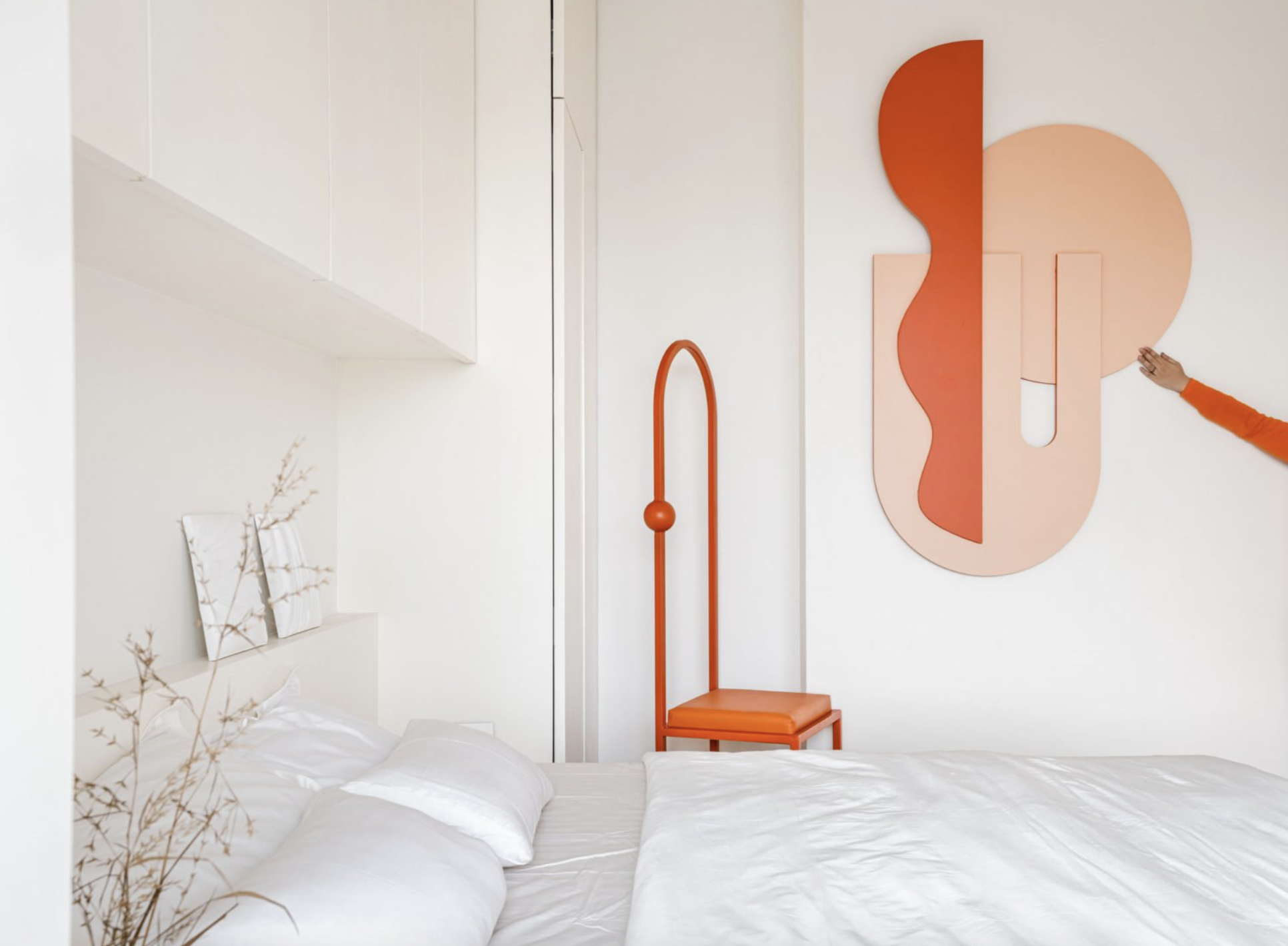dormitorio en blanco y silla y pieza de pared en naranja fluor