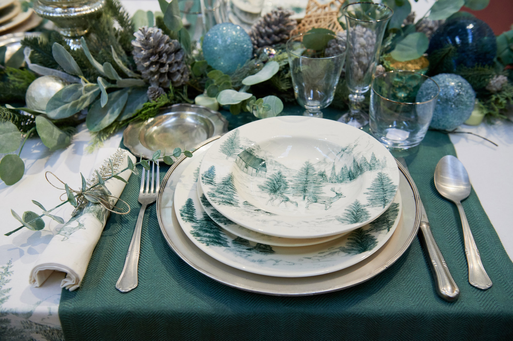 mesa navidad verde con vajilla con detalles de un bosque nevado