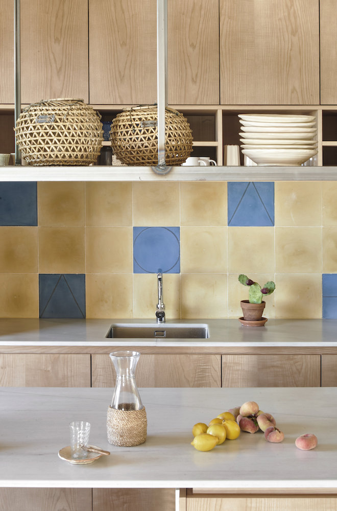 Cocina con azulejos azules y amarillos de una Casa en Mallorca del estudio de arquitectura OHLAB