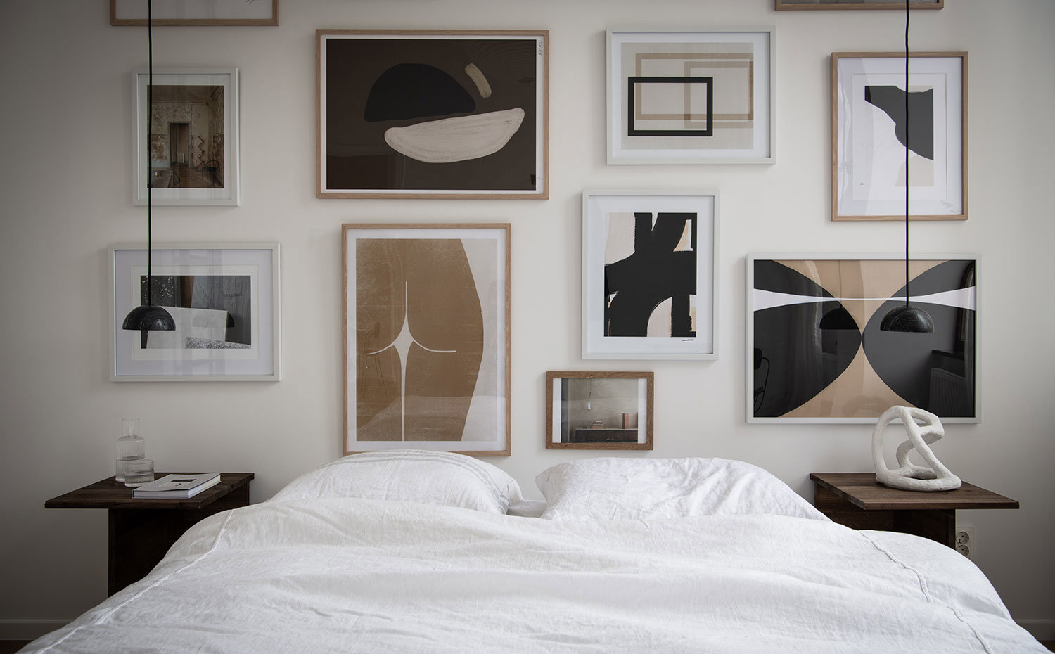 Dormitorio con la pared del cabecero con cuadros.
