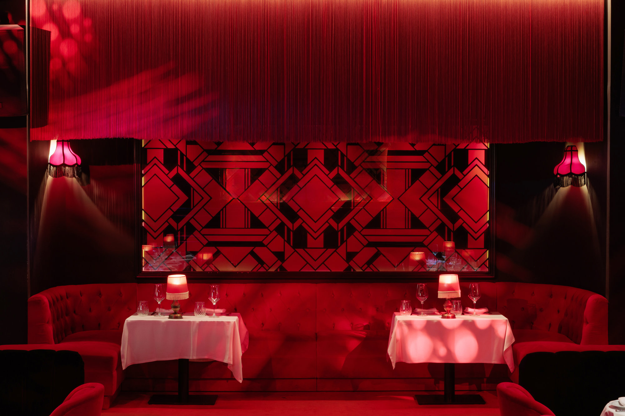 interior local motel particulier del grupo mosh, todo en color rojo y con estilo de cabaret de los años 20