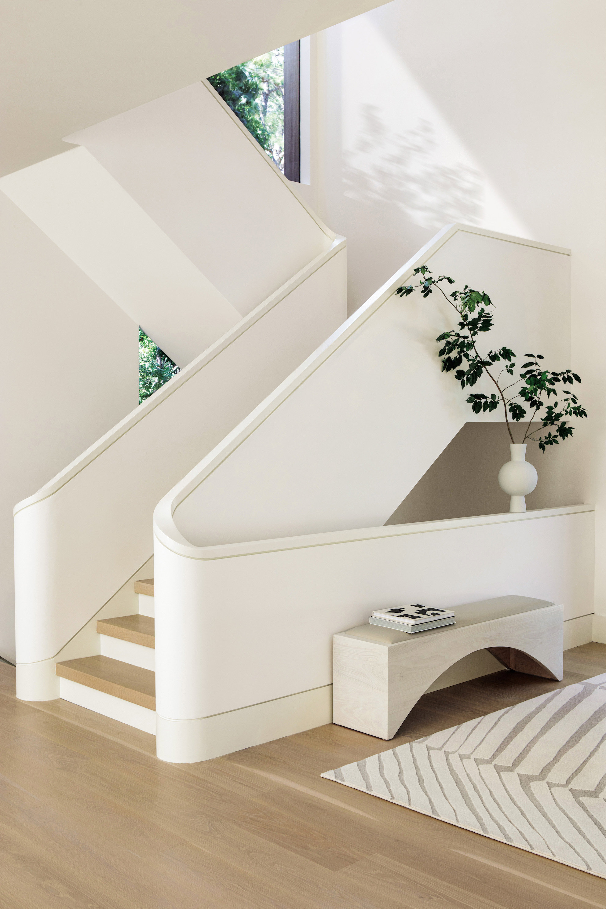 Escaleras blancas con suelos de madera.