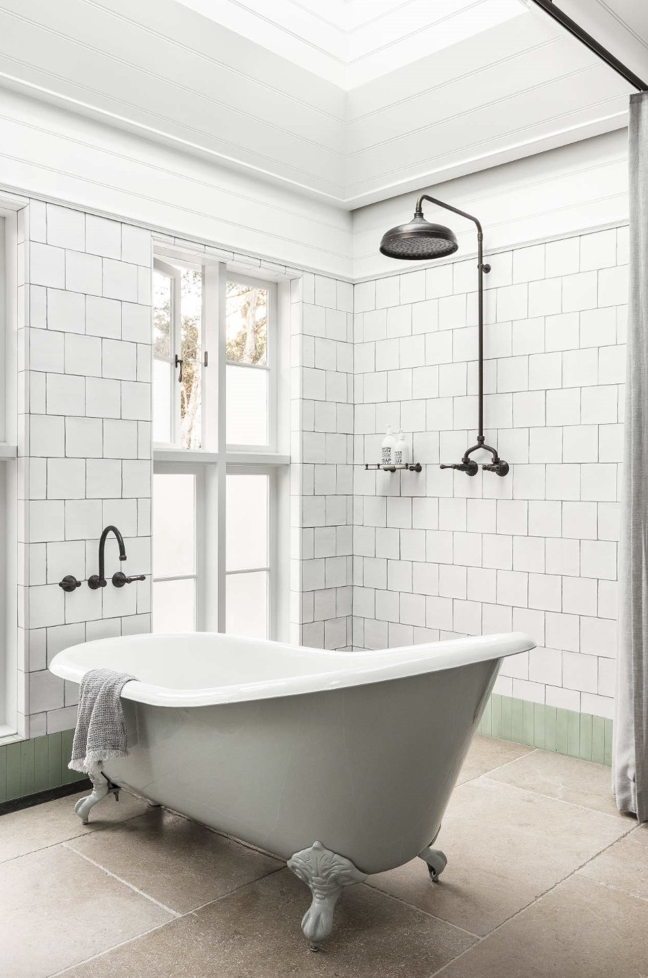baño de estilo antiguo en blanco, bañera con patas rodeado de ventanas