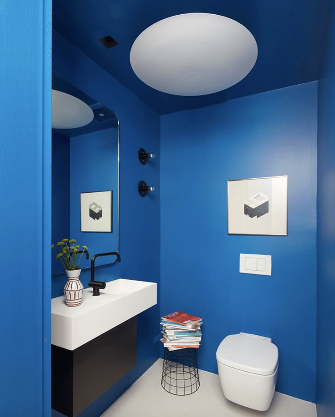 cuarto de baño en azul con grifería negra.