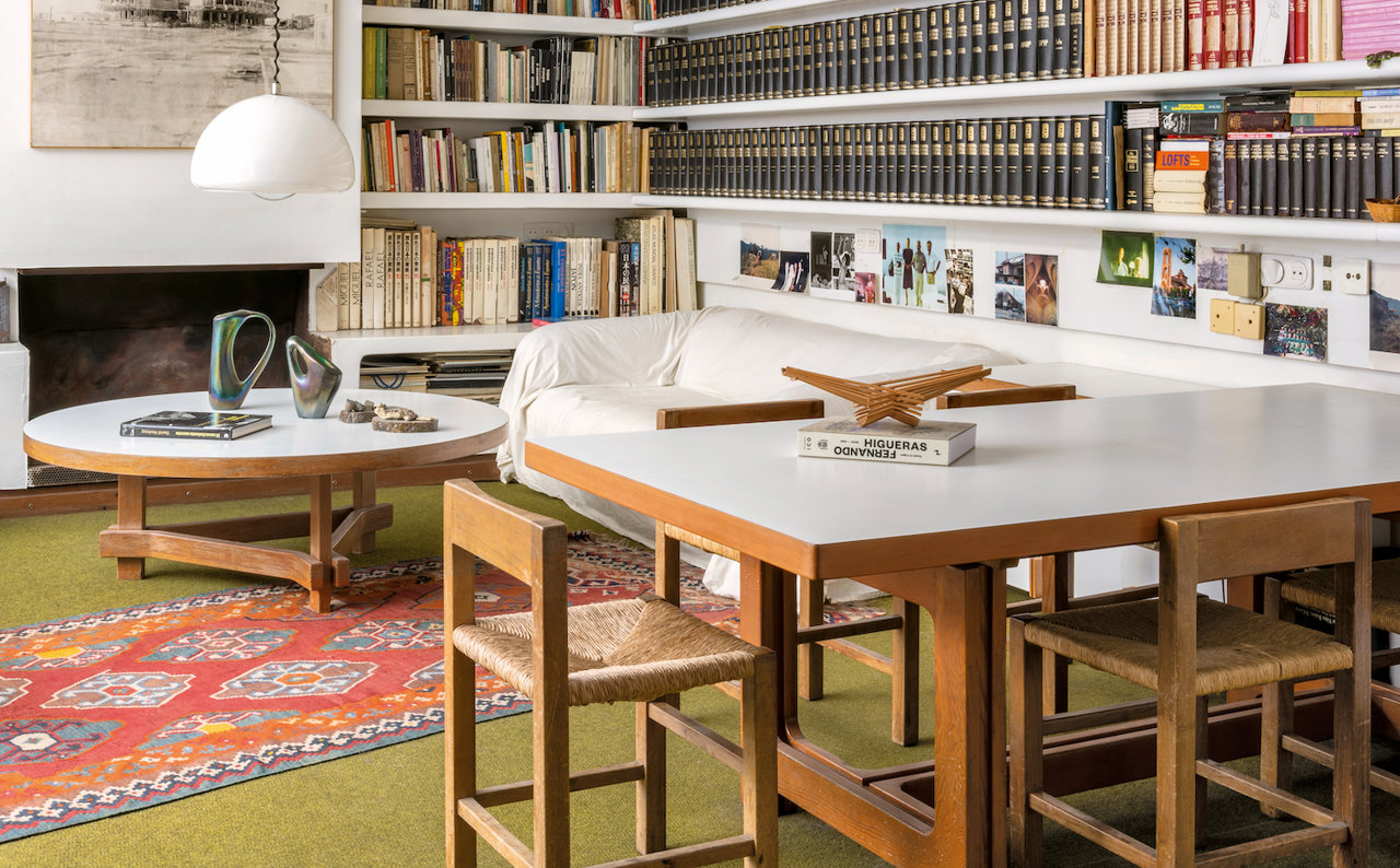 Una sala de estar acogedora con chimenea con mesas y sillas diseño de Higueras, uno de los espacios del Rascainfiernos. 