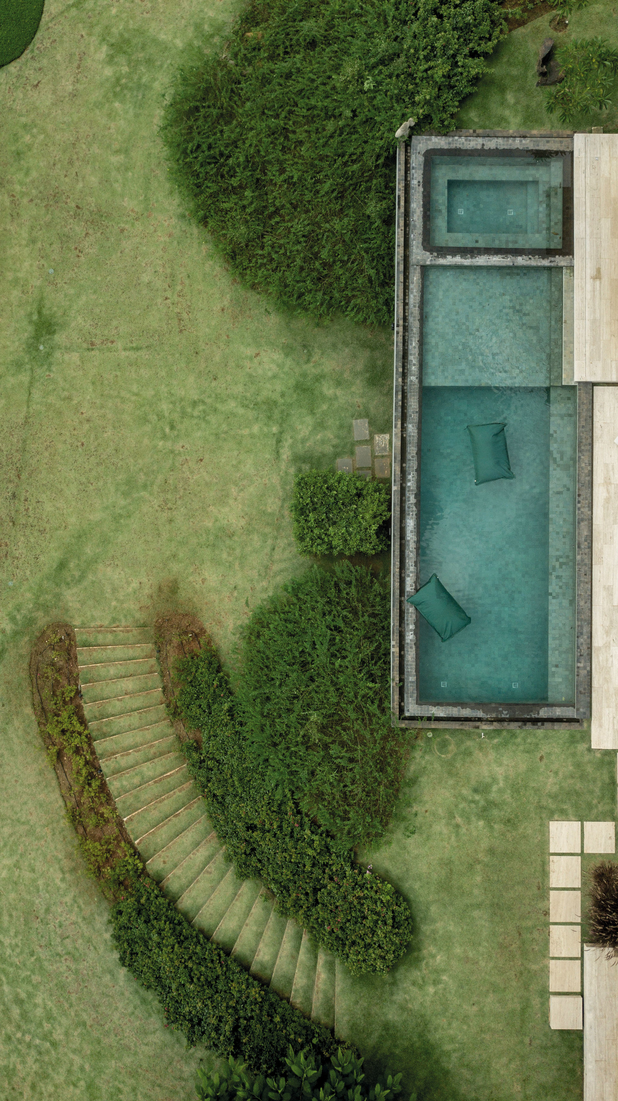 Vista aérea de una casa con piscina rodeada por naturaleza. 