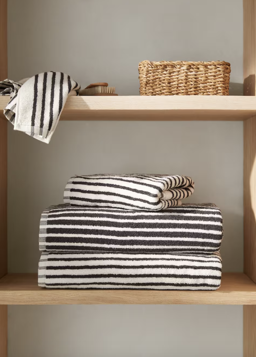 juego de toallas de baño a rayas blancas y negras en una estantería