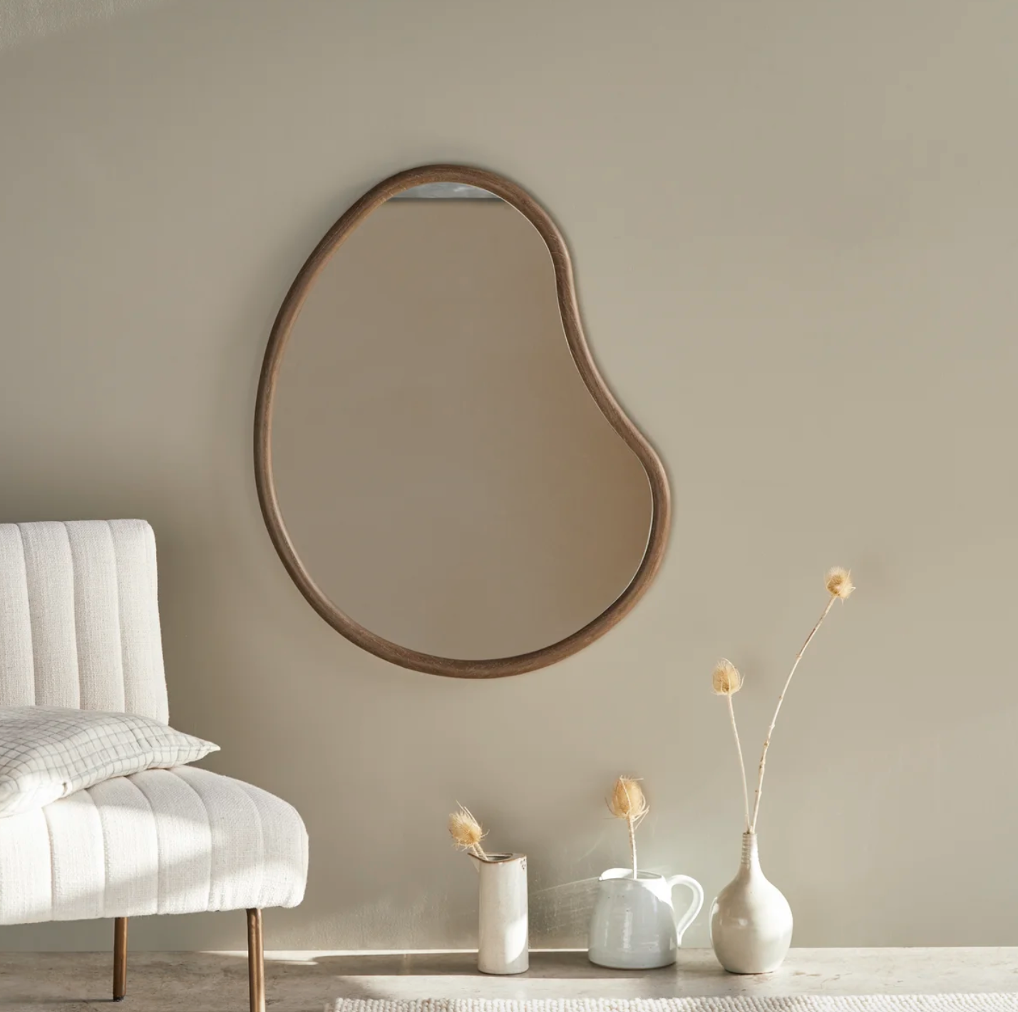 espejo de madera con sofá y jarrones blancos al lado