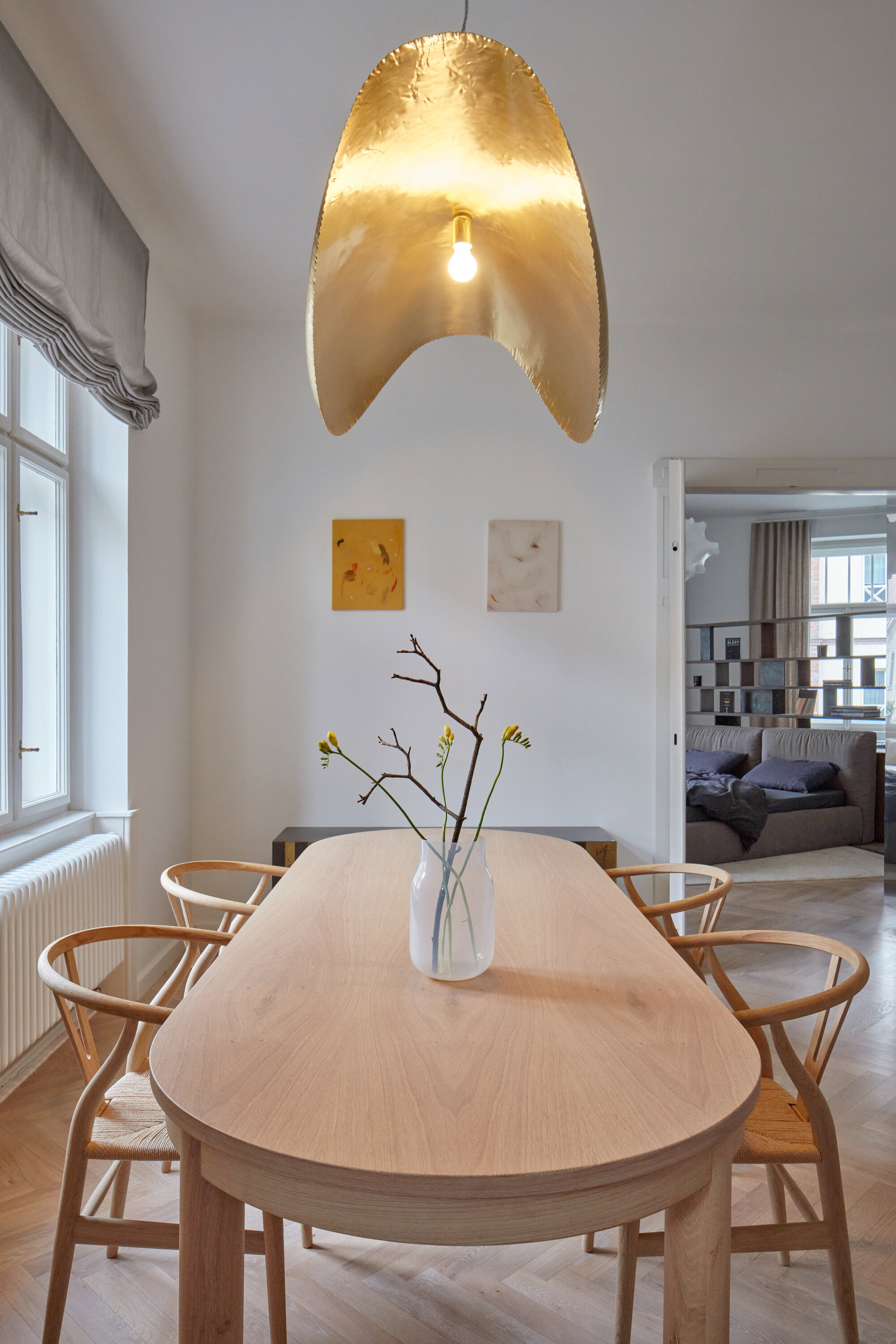 comedor con mesa y sillas de madera y lámpara dorada