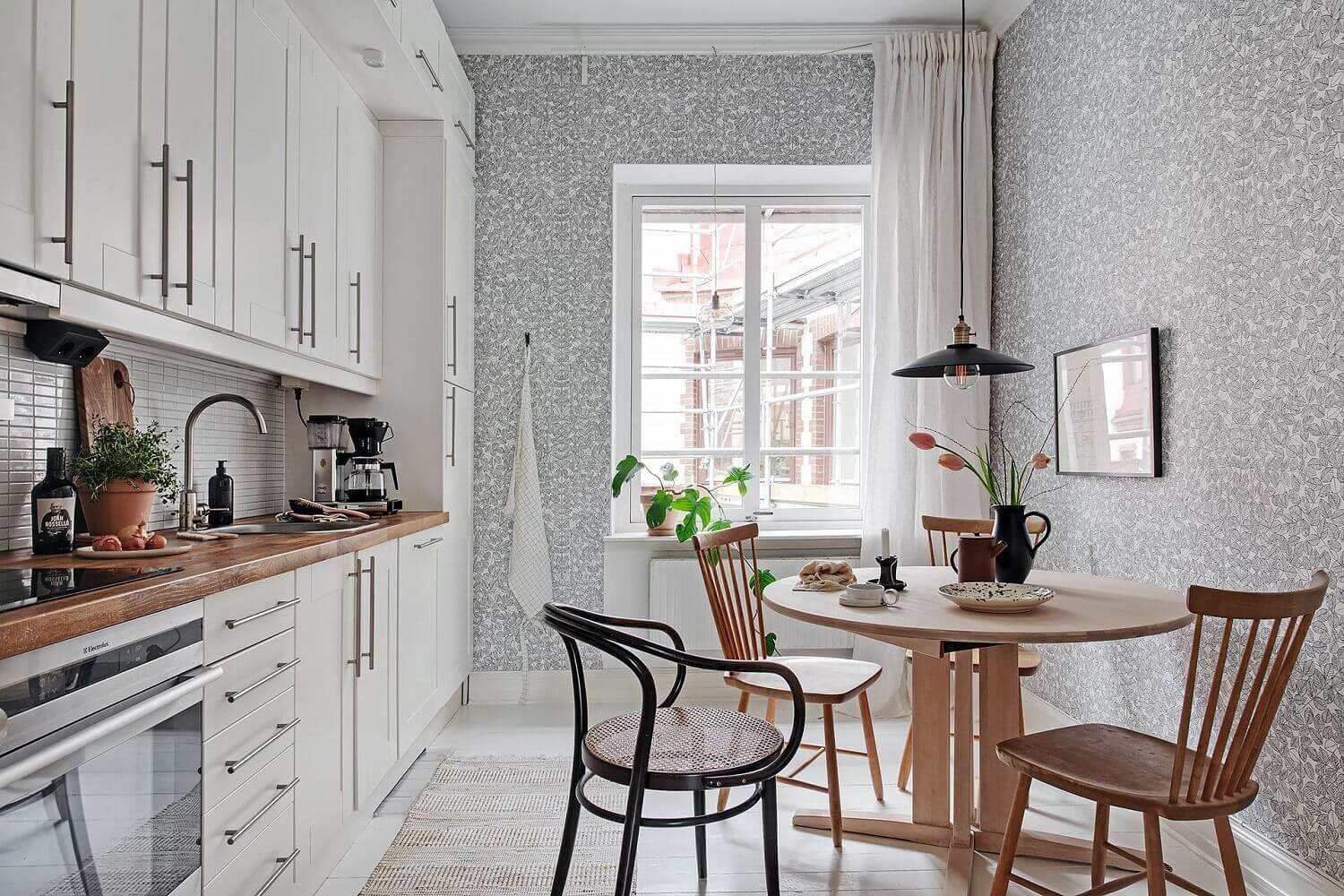 Casa con cocina con mesa de comedor incorporada de estilo nórdico