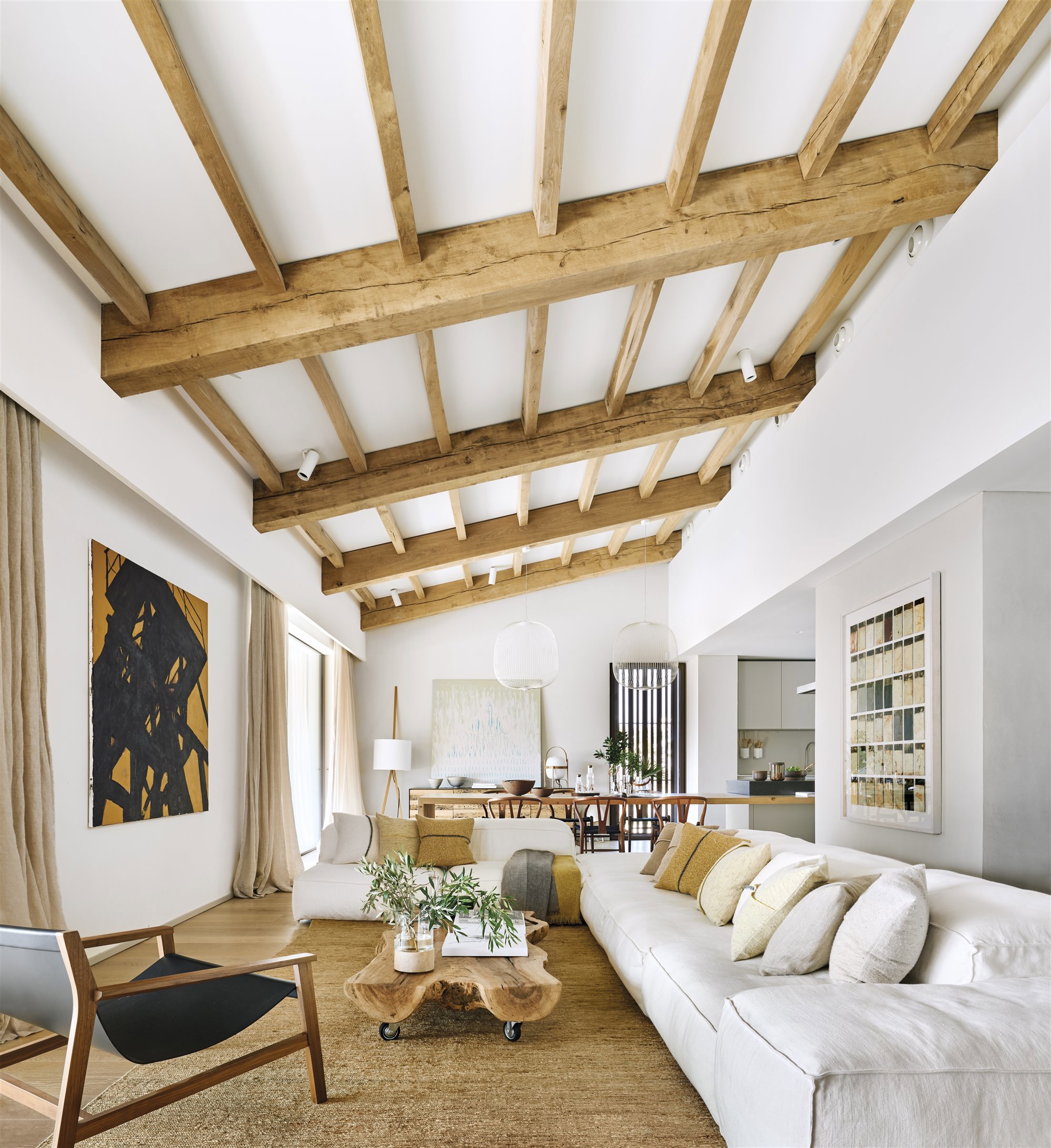 Salon de una casa moderna con vigas de madera vistas y sofa´ blanco