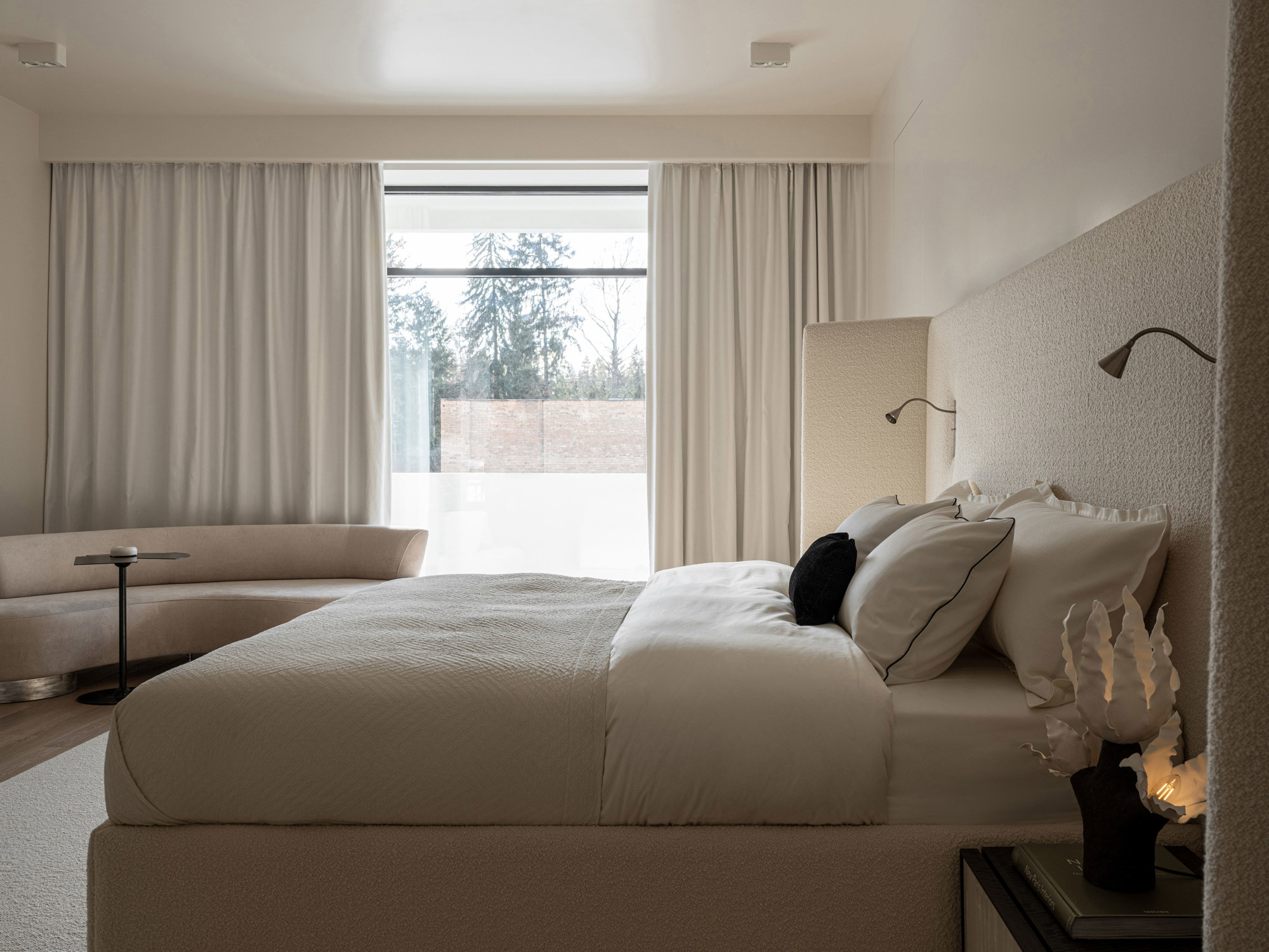 dormitorio en blanco con grandes ventanas y cortinas
