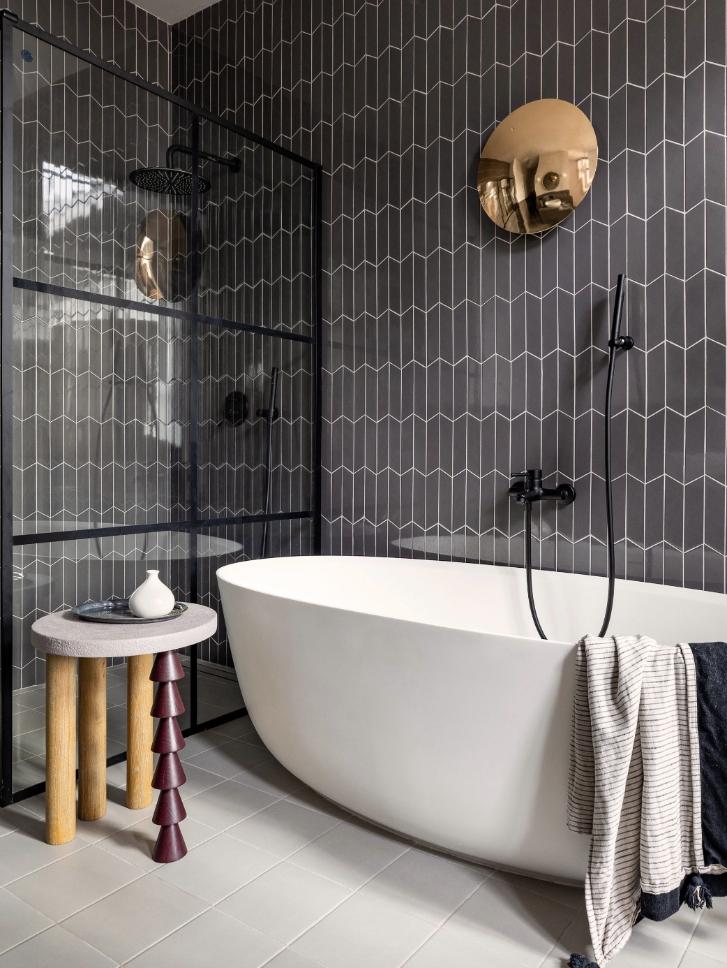 baño con bañera exenta en blanco y azulejos en morado oscuro