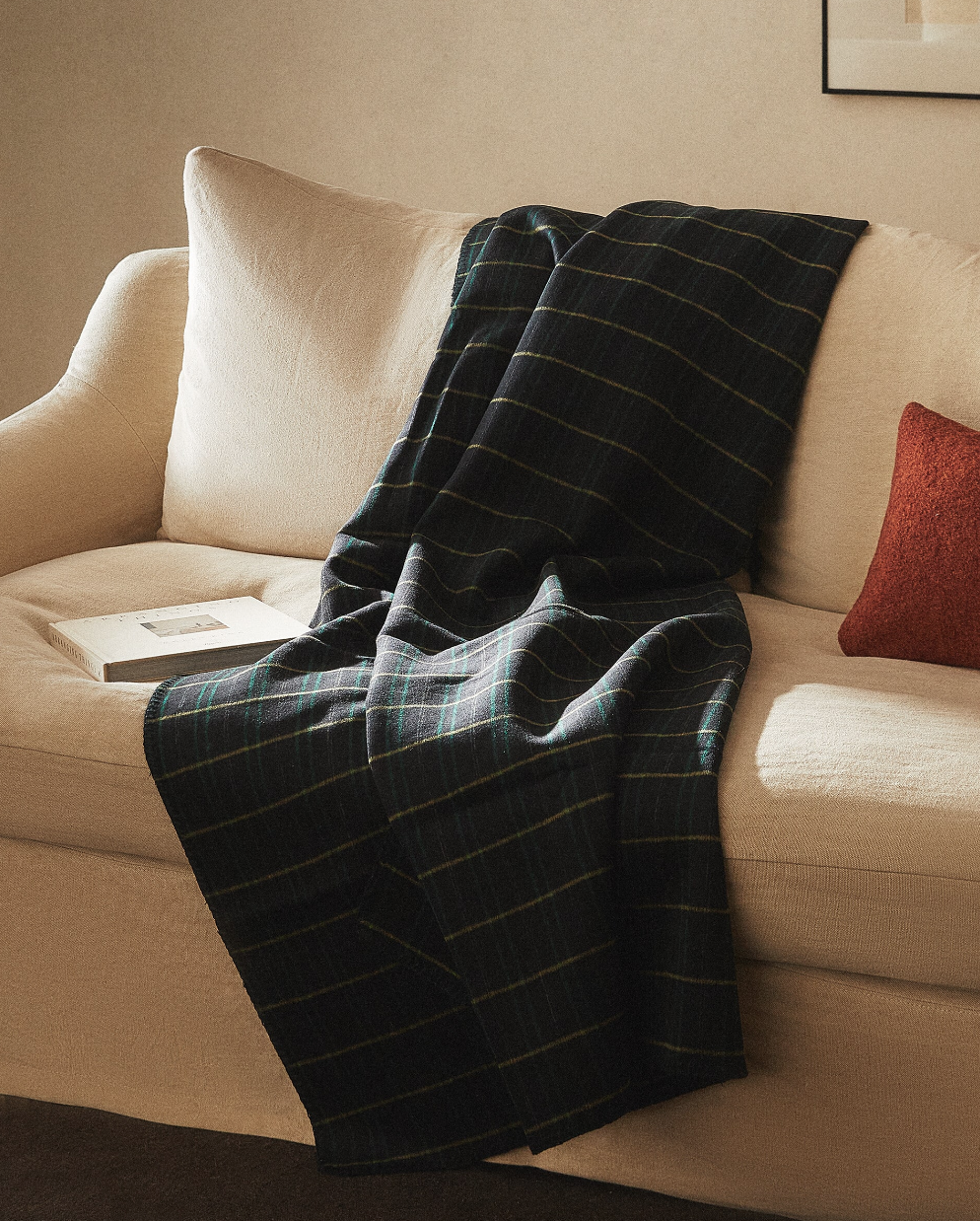 manta de lana cuadros tartán sobre sofá blanco zara home