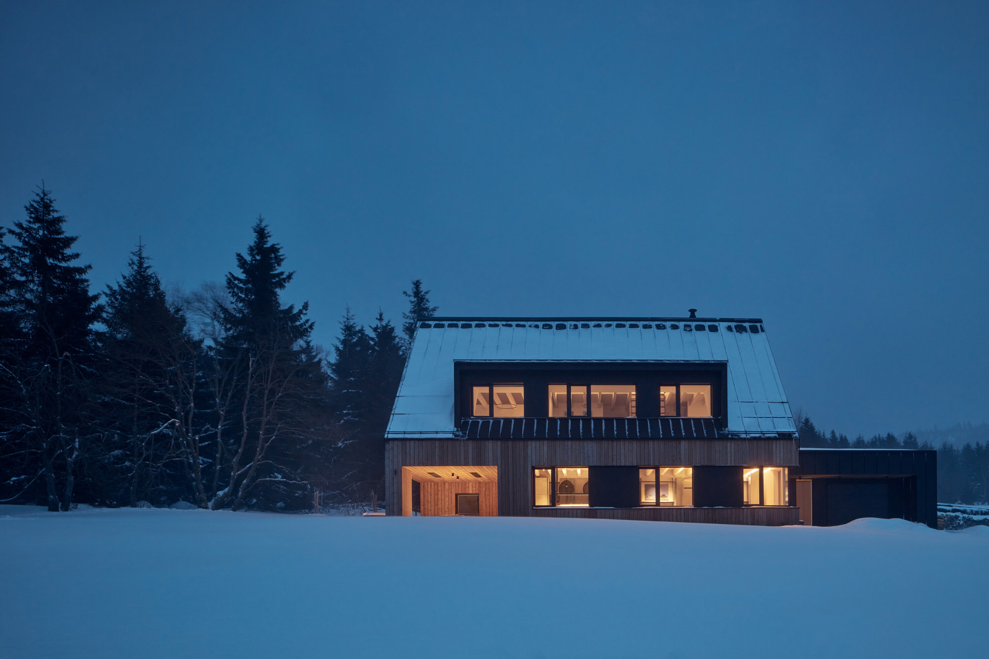 fotografía nocturna de fachada de casa de madera como Refugio de invierno ADR Formafatal en República Checa